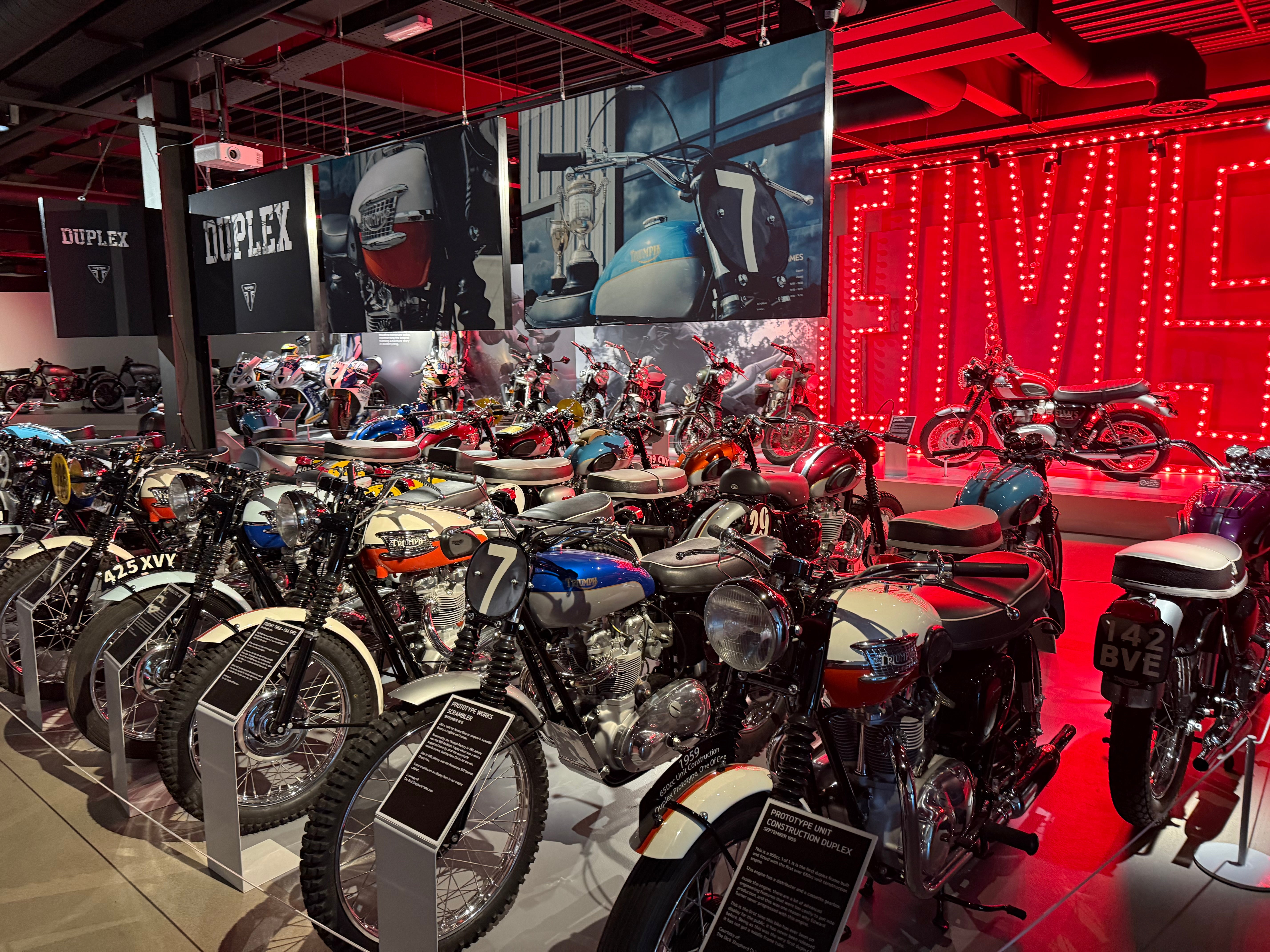 Classic motorcycles lined up on display in a museum showroom